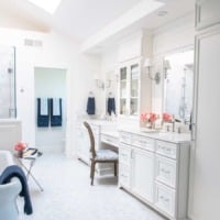 French elegant white marble master bathroom with double vanities and freestanding tub