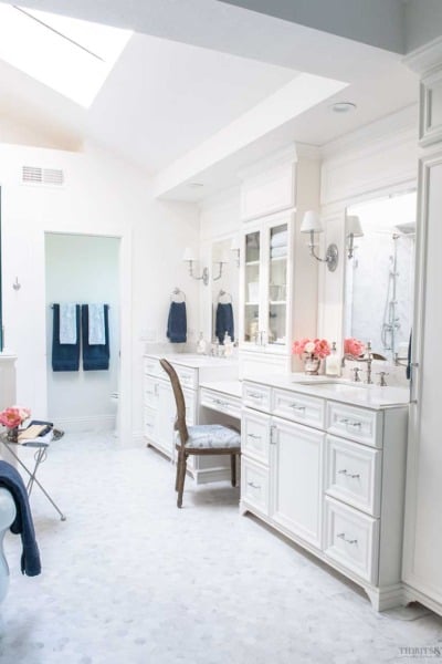 French elegant white marble master bathroom with double vanities and freestanding tub