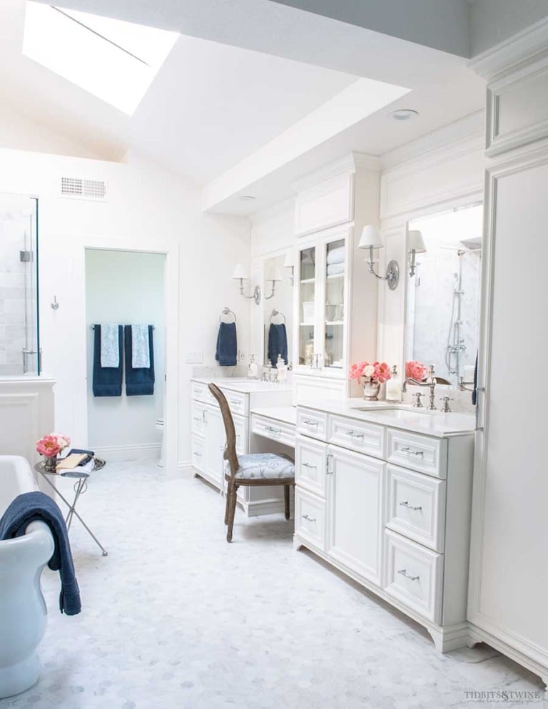 French elegant white marble master bathroom with double vanities and freestanding tub