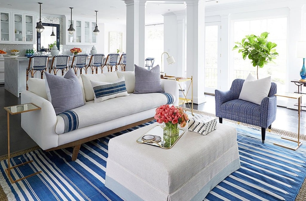 Great room with white sofa and blue stripe rug and white walls