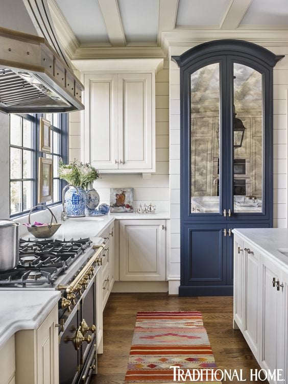 Traditional kitchen with white cabinets and blue built in refrigerator with mirrored doors