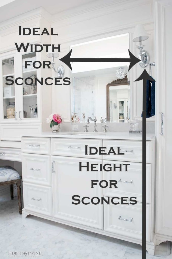 white french bathroom with carrera marble and text overlay for ideal width and height of sconces