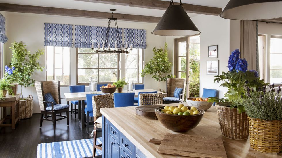 Kitchen with blue cabinets and butcher block countertop and blue chairs