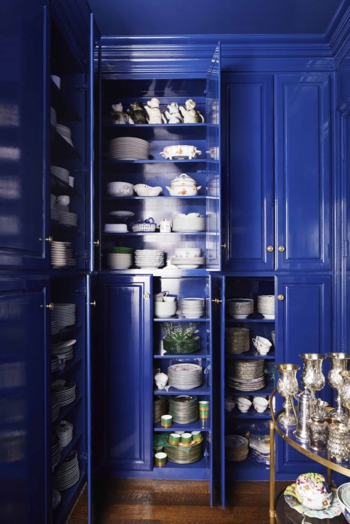 Farrow and Ball glossy blue cabinets in butlers pantry with white dishes