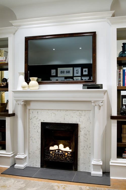TV above fireplace covered by mirror
