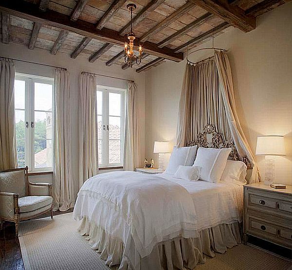 European bedroom with canopy above bed and wooden beam ceiling