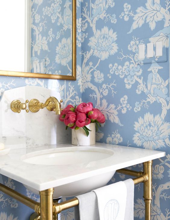 Bathroom with blue floral wallpaper and gold accents