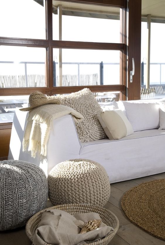 Grouping of poufs used as a side table next to a white sofa in a living room