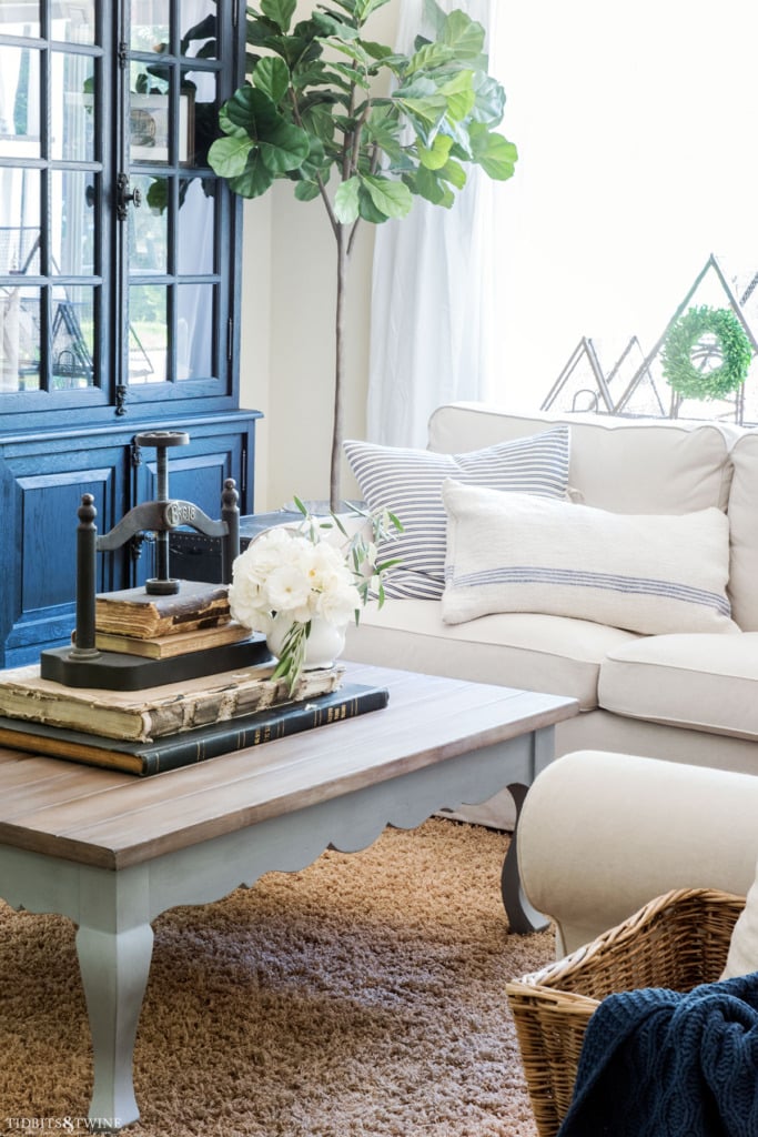 French style family room with chalk painted coffee table with book press on top