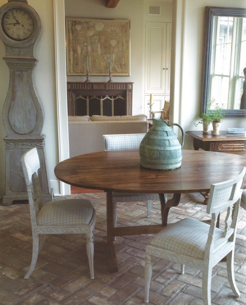 gustavian dining area with herringbone brick floor and round table with mora clock