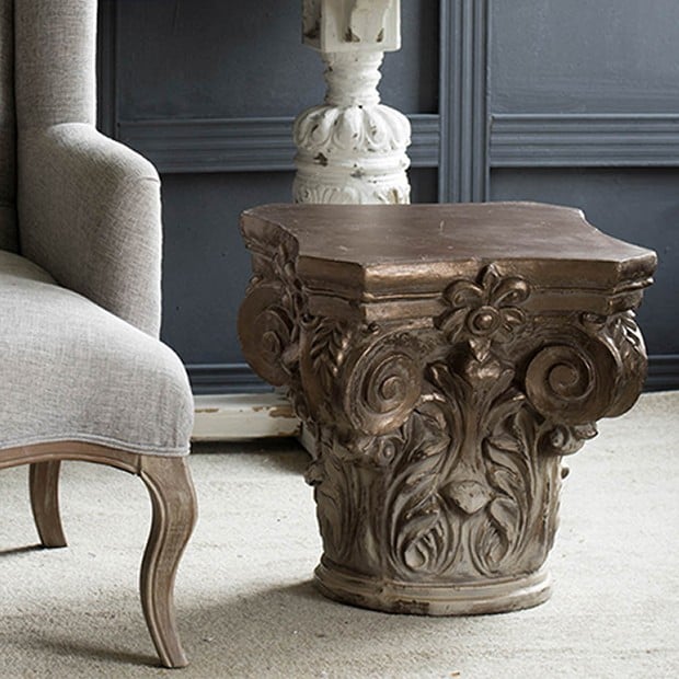 architectural pedestal side table next to french chair