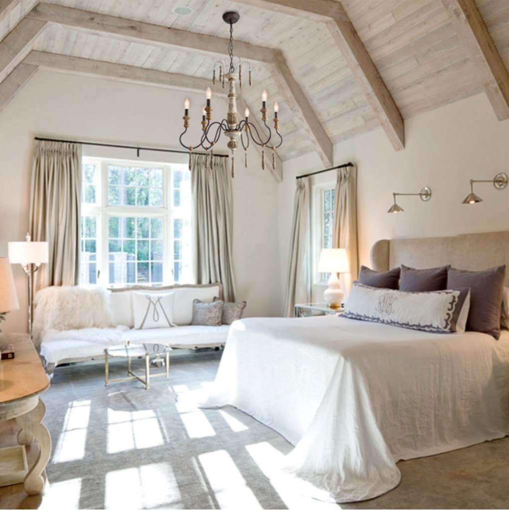 French bedroom with wood ceiling and french country chandelier above the bed