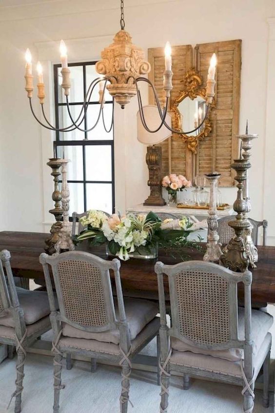 French country dining room with antique chairs and wood carved chandelier