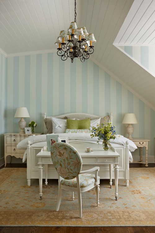 bedroom with striped wallpaper and desk at foot of bed