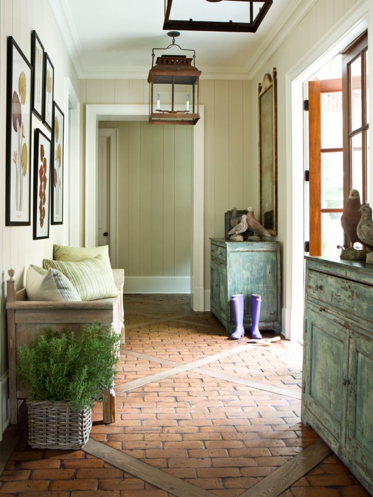 Entryway with brick floors blue vintage cabinets and hanging lantern