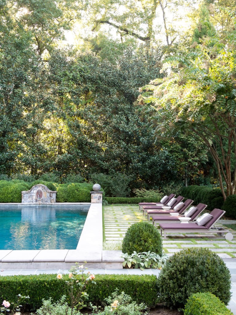 french backyard poor with fountain boxwoods and grass between pavers