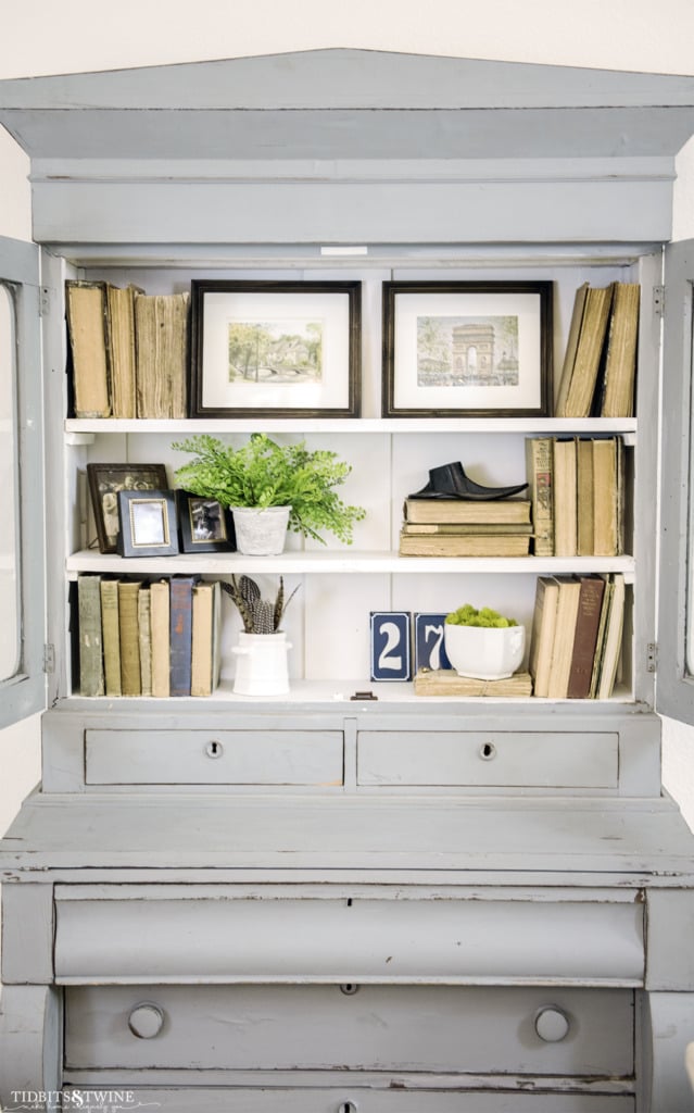 Blue gustavian hutch with antique books, art and organic items