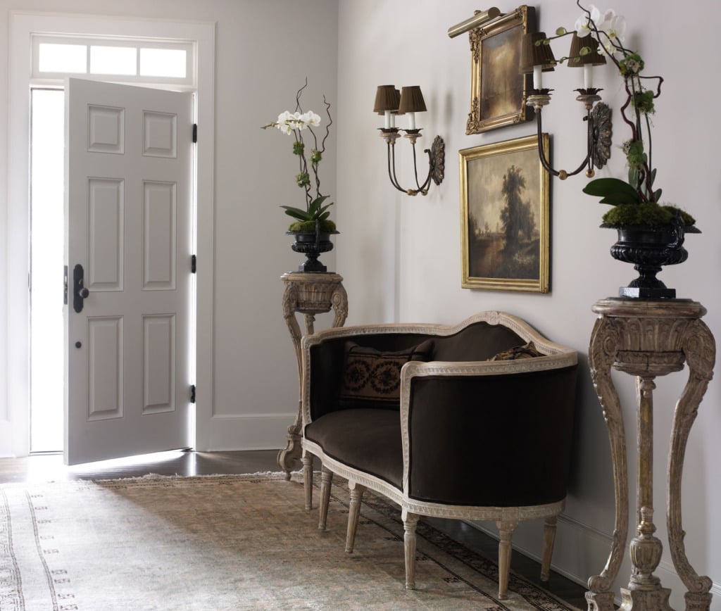 elegant foyer with french velvet settee flanked by orchids on stands