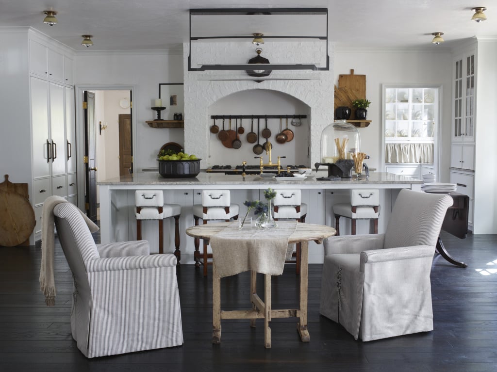 White kitchen with brick range french antiques and wine table sitting area