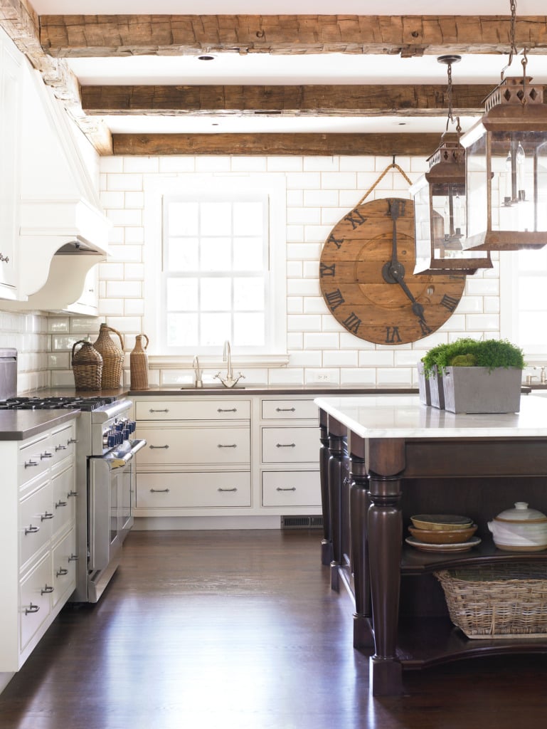 White kitchen with subway tile and dark wood island with antiques