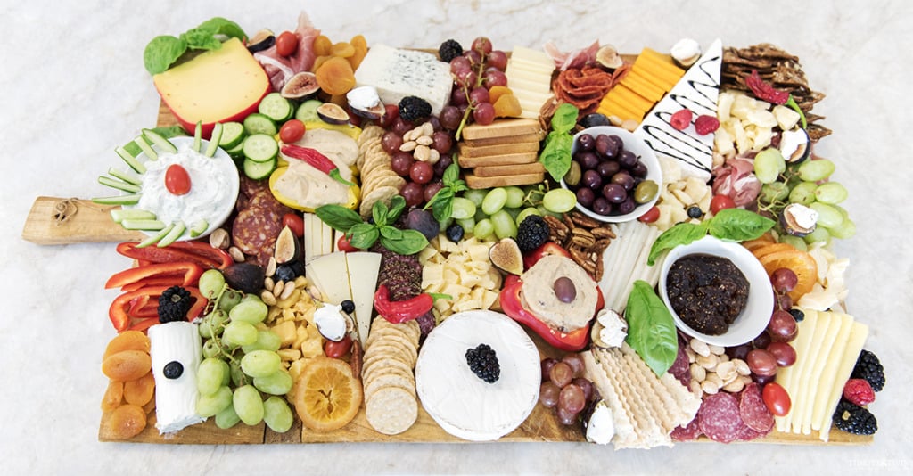 DIY delicious oversized charcuterie board with meats cheeses nuts fruits and vegetables