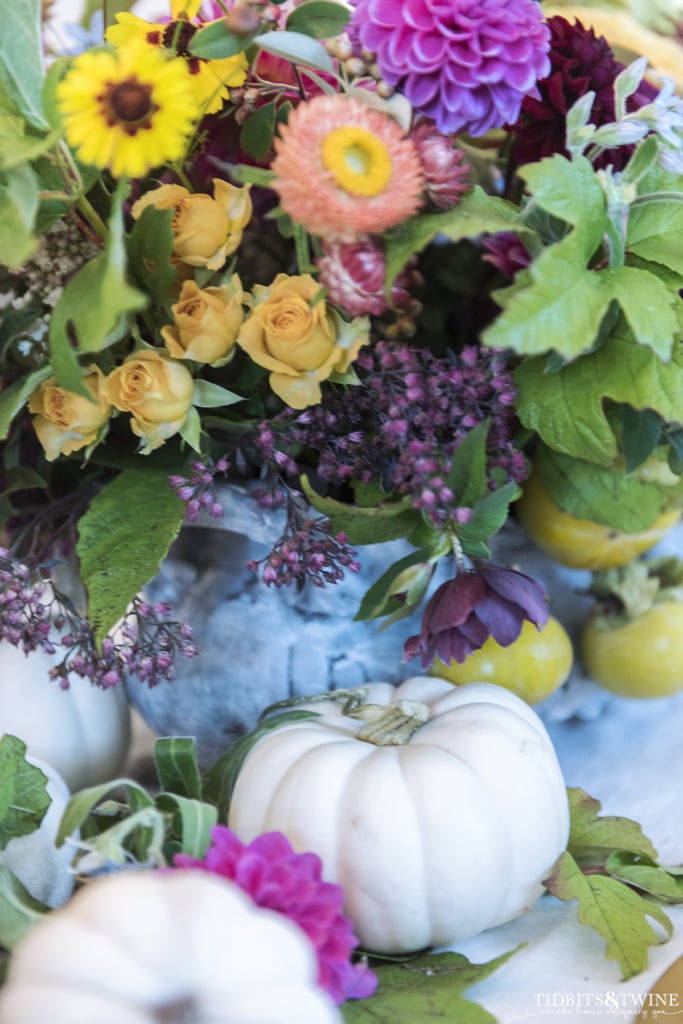 eclectic mix of french flowers for fall with white baby boo pumpkins on table centerpiece