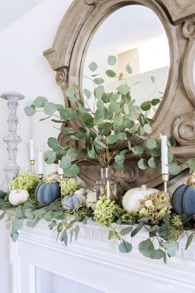 Fall french mantel decorated with eucalyptis white and blue pumpkins and candlesticks