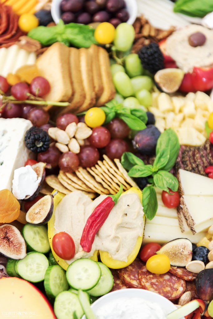 Delicious charcuterie board showing yellow pepper cut in half with hummus inside