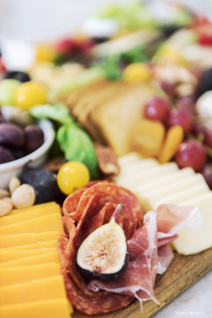 Closeup of charcuterie board showing salami with sliced fig in the center