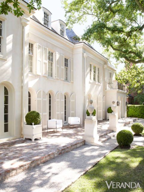 Two store white chateau with arched windows and french planter boxes