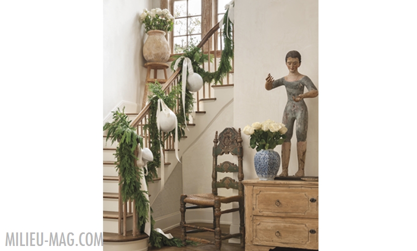 Plaster and wood stairs with cedar garland and white ornaments