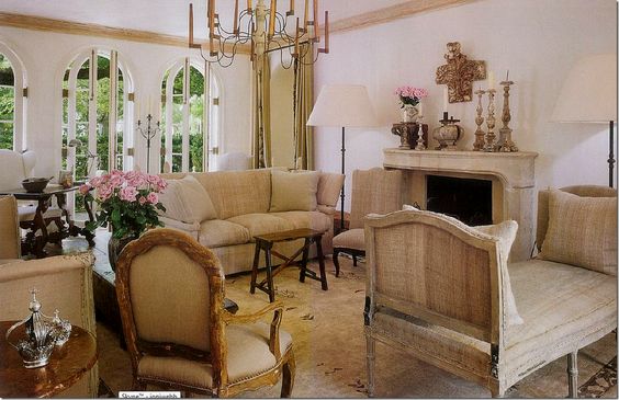 Neutral French living room with linen furniture and stone fireplace
