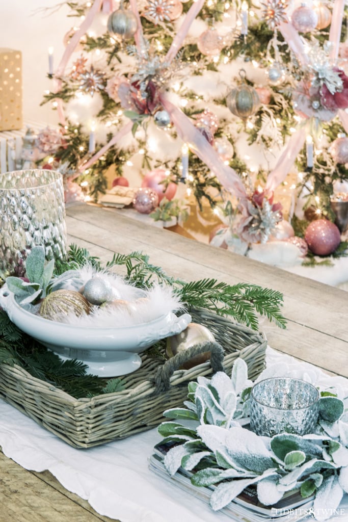 Industrial coffee table decorated for Christmas with pink ornaments and greenery