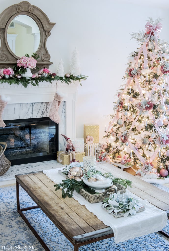 Pink and white Christmas living room with decorated fireplace and tree