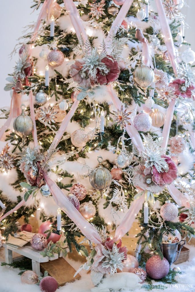 Crisscross ribbon on a pink Christmas tree with gold and silver accents