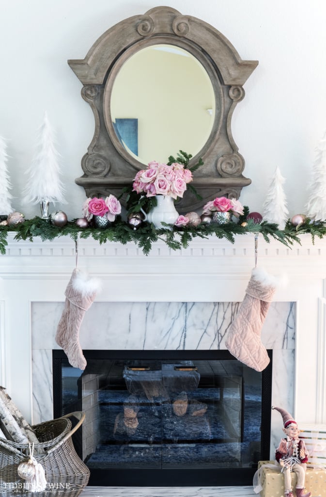 Pink and white Christmas fireplace mantel decor with mirror above