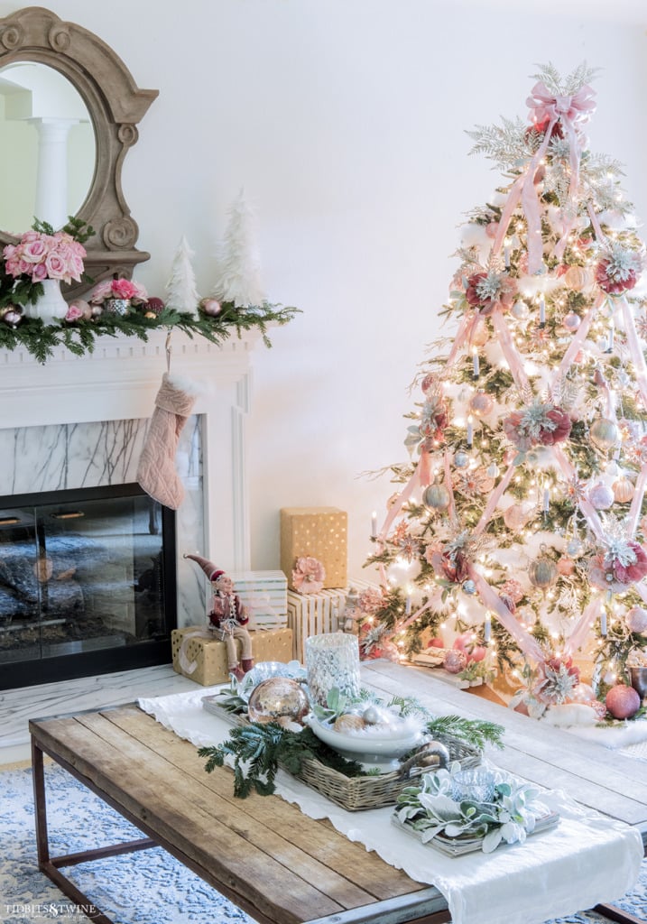 French living room with fireplace decorated for Christmas with pink and white tree