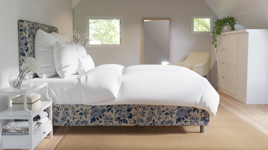 White bedroom with blue chintz upholstered bed with white bedding