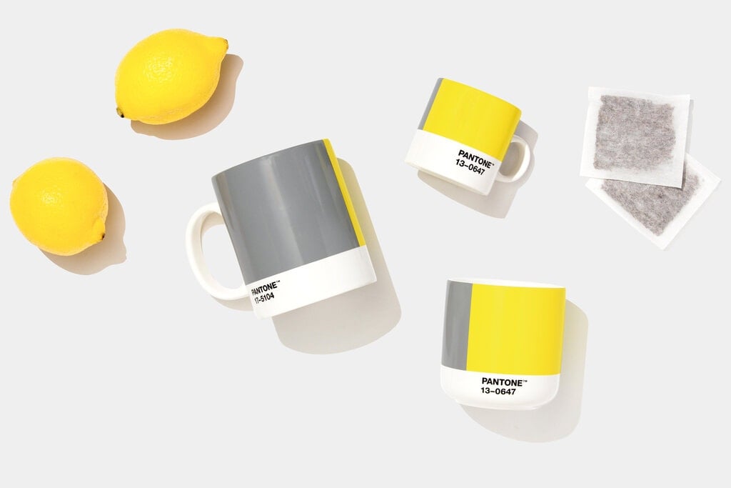 Pantone 2021 color of the year gray showing gray and yellow coffee mugs and lemons on a gray background