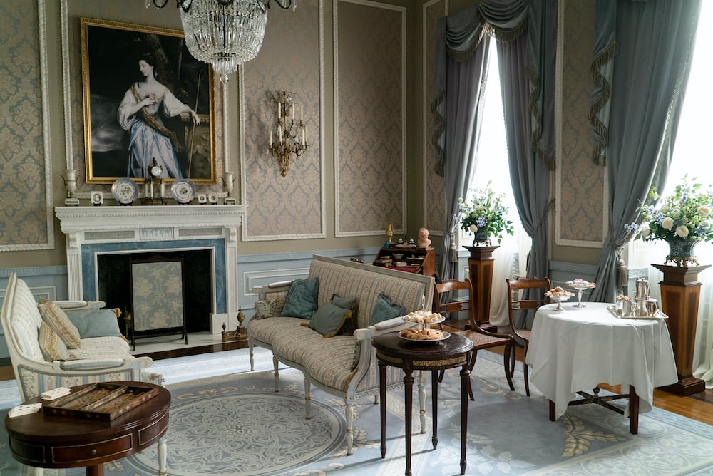 Netflix Bridgerton living room with blue and beige wallpaper and Regency furnishings