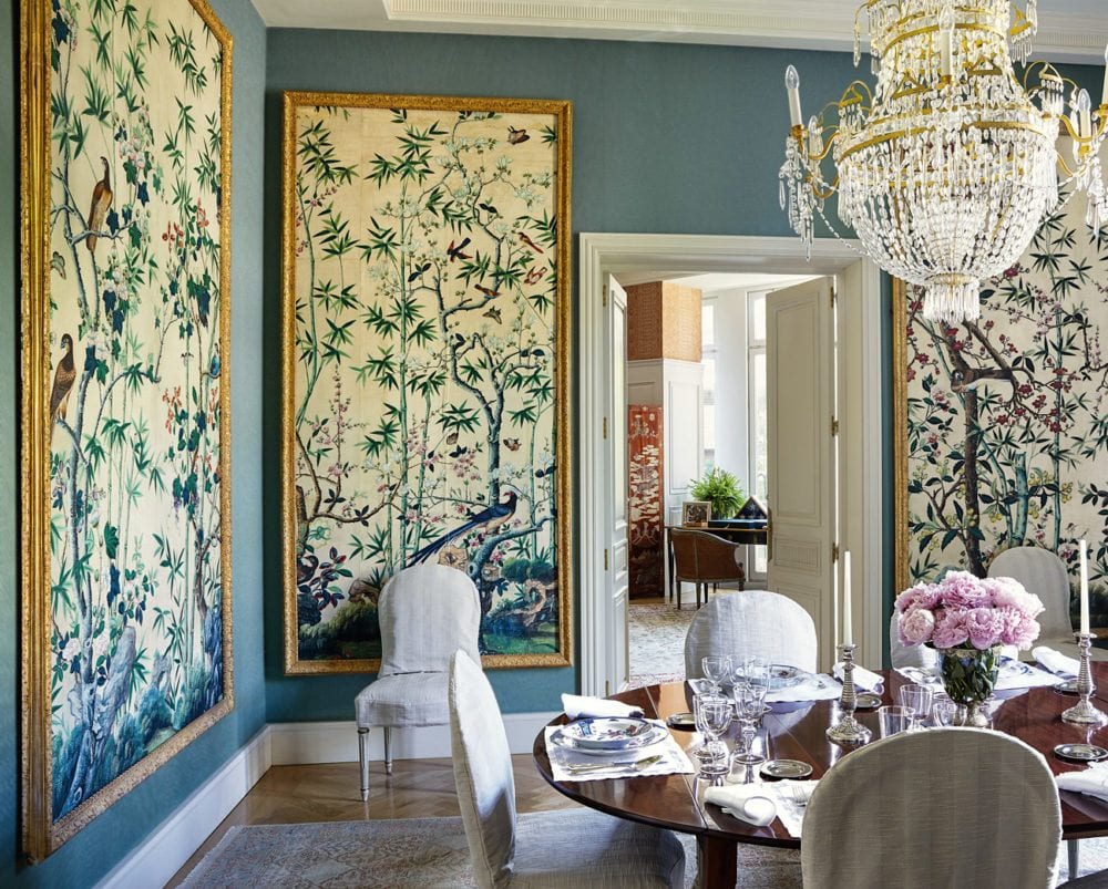 Turquoise dining room with chinoiserie panels framed in gold with dark wood table and linen chairs