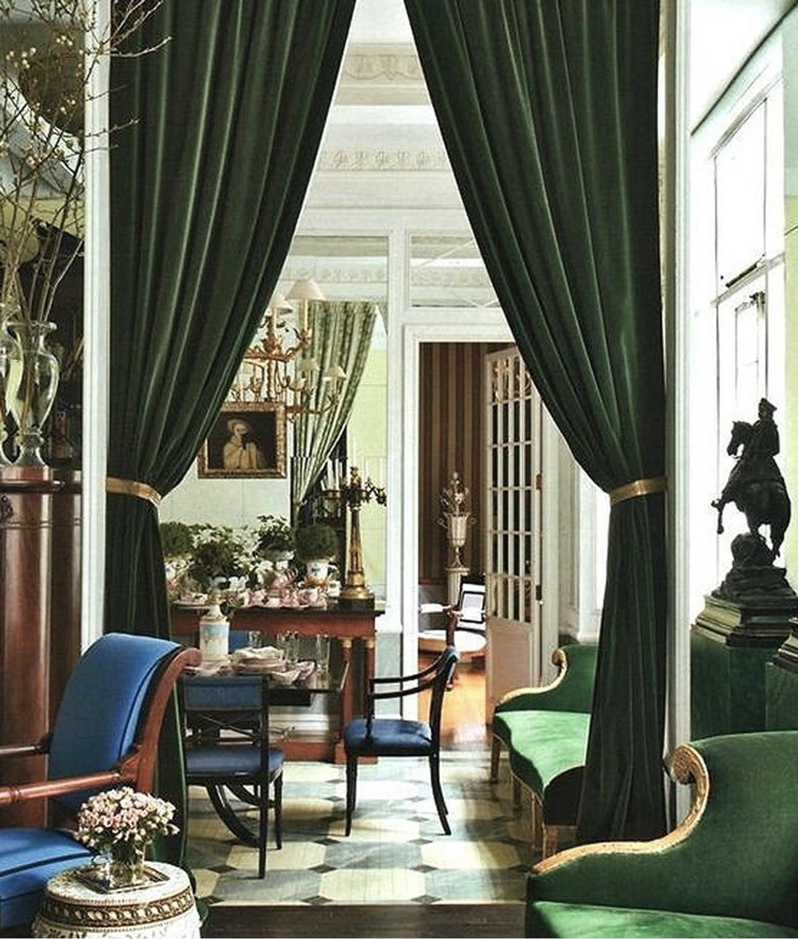Green velvet curtains flanking entrains to a regency style dining room