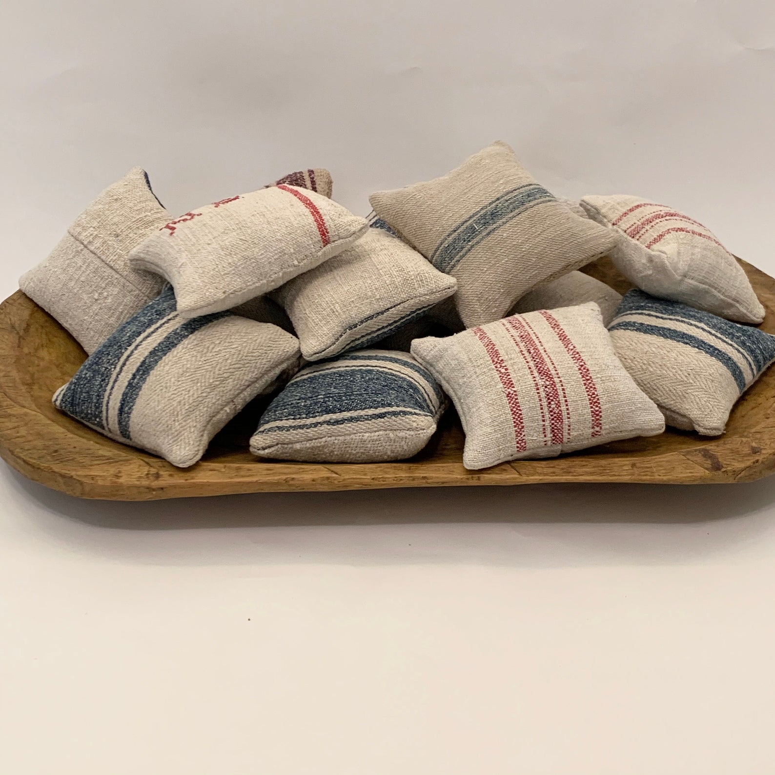 Wooden bowl full of small lavender sachets made out of French vintage grain sacks