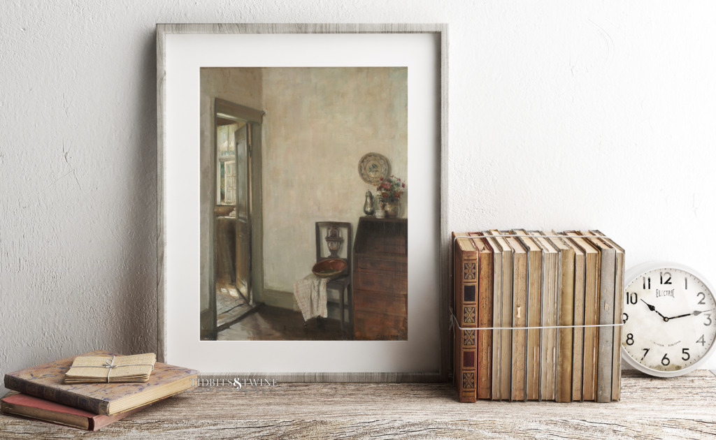 Framed artwork of Carl Holsoe on shelf with antique books and old alarm clock