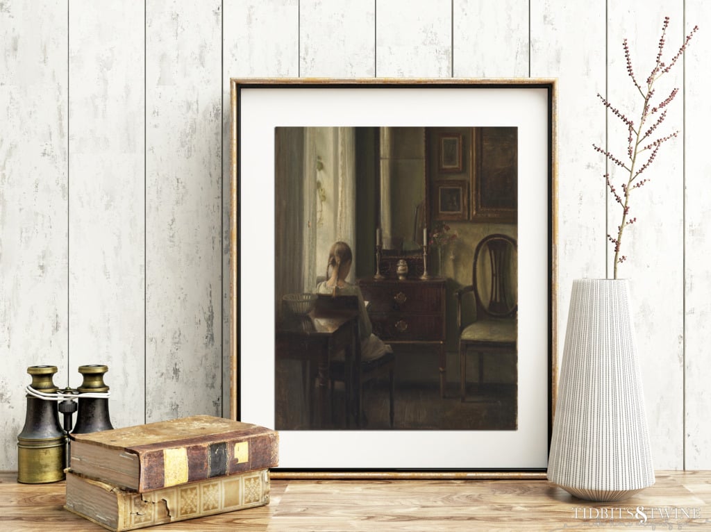 Gold framed Carl Holsoe art of back of girl sitting reading book