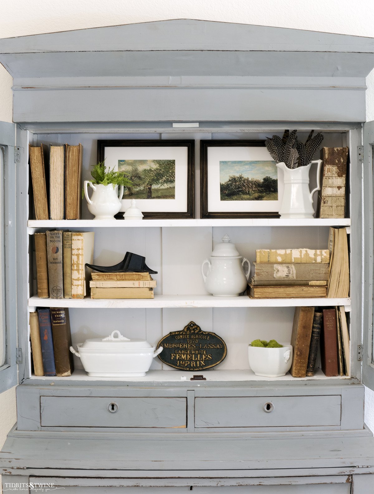 Blue french hutch styled with antique books and artwork for Spring