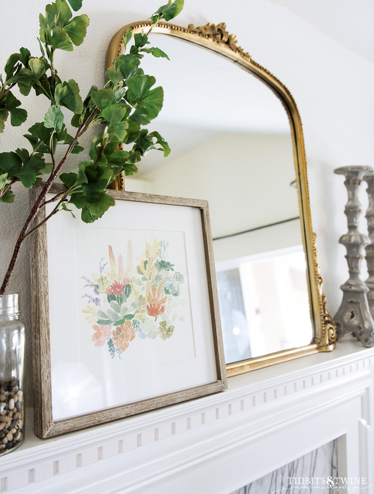 Closeup of french fireplace mantel with gold mirror and art styled on top