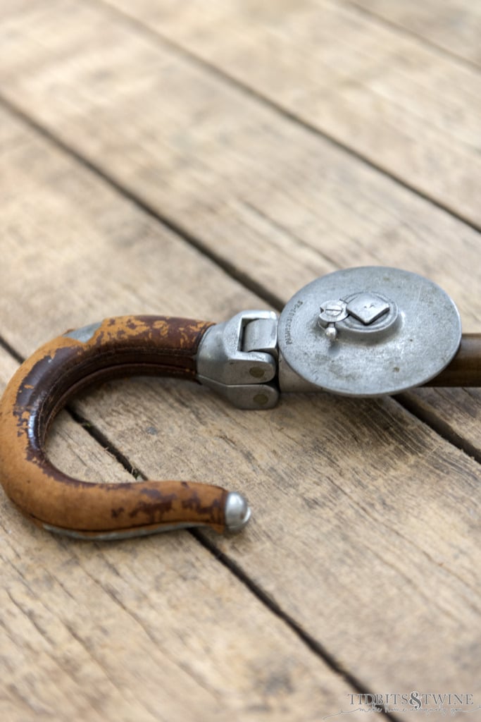 closeup of hook shaped folding seat gadget cane on pallet table