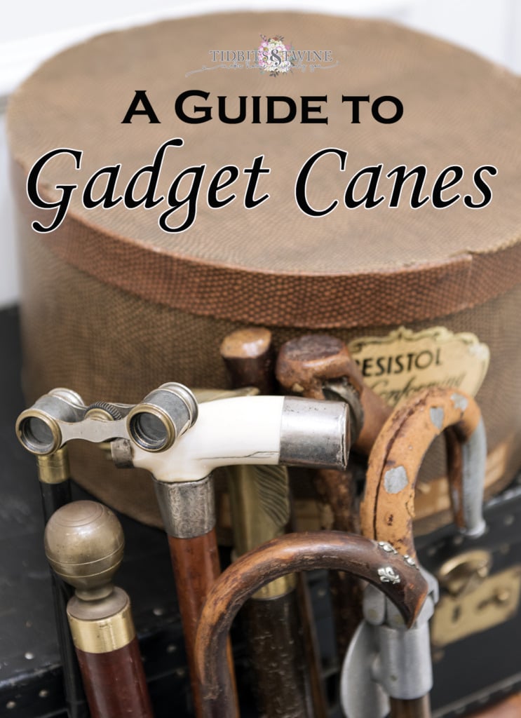 Collection of antique gadget canes propped up on vintage suitcases