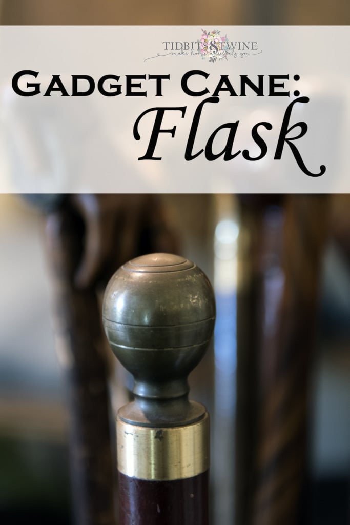 closeup of antique flask gadget cane with metal ball handle